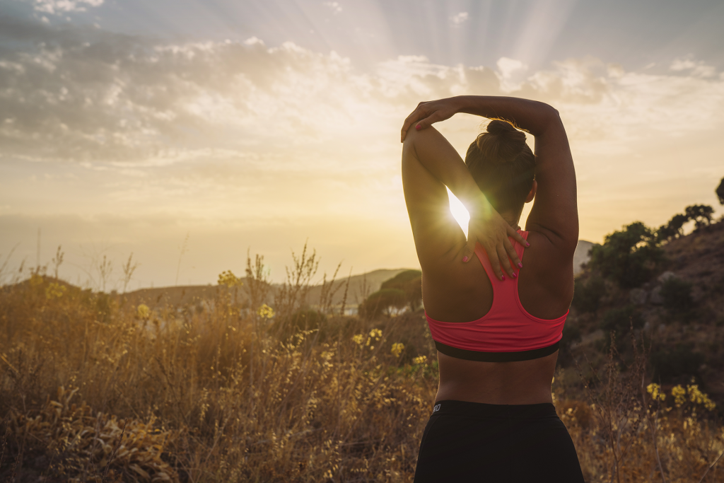 mulher fazendo alongamento antes do exercício